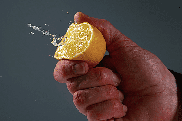 Мужчина давит половинку лимона